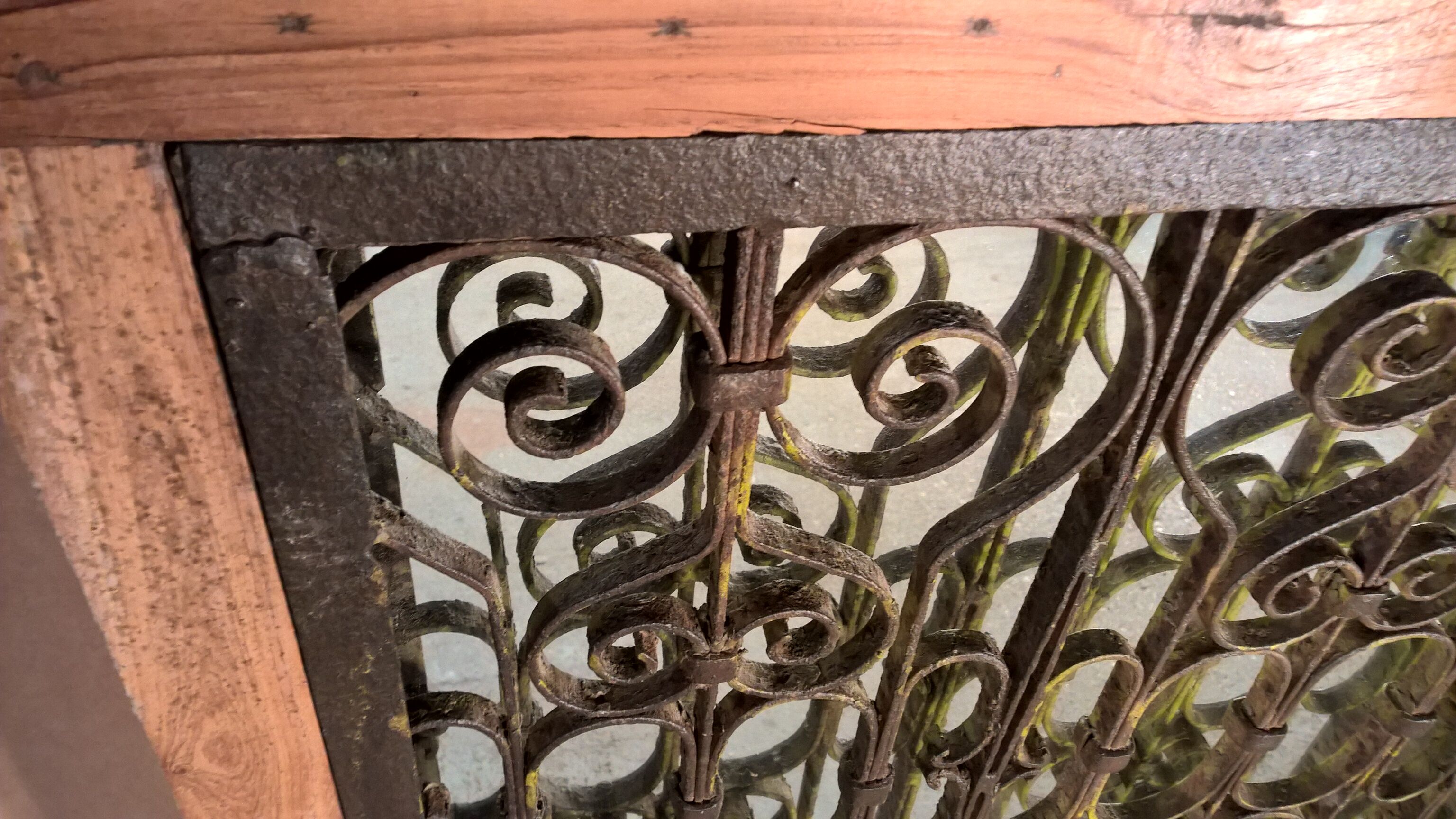 Old wrought iron railing with mirror and teak frame