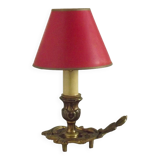 Vintage French bronze Wee Willie Winkie style lamp with red card shade.