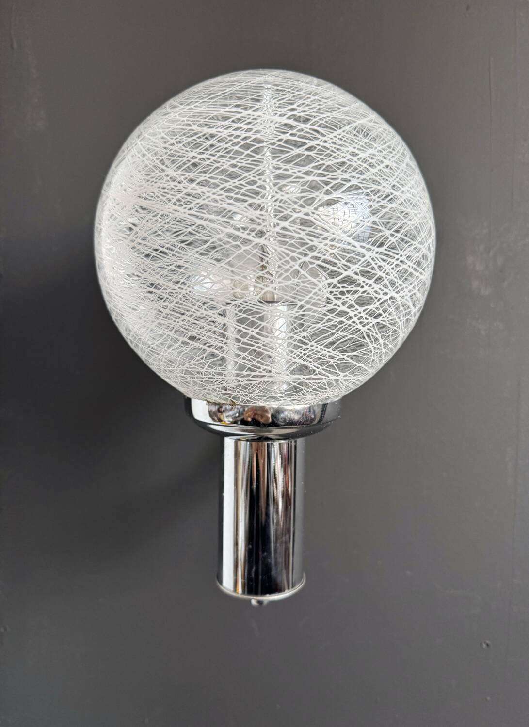 Chrome wall light with blown glass from the 1970s.
