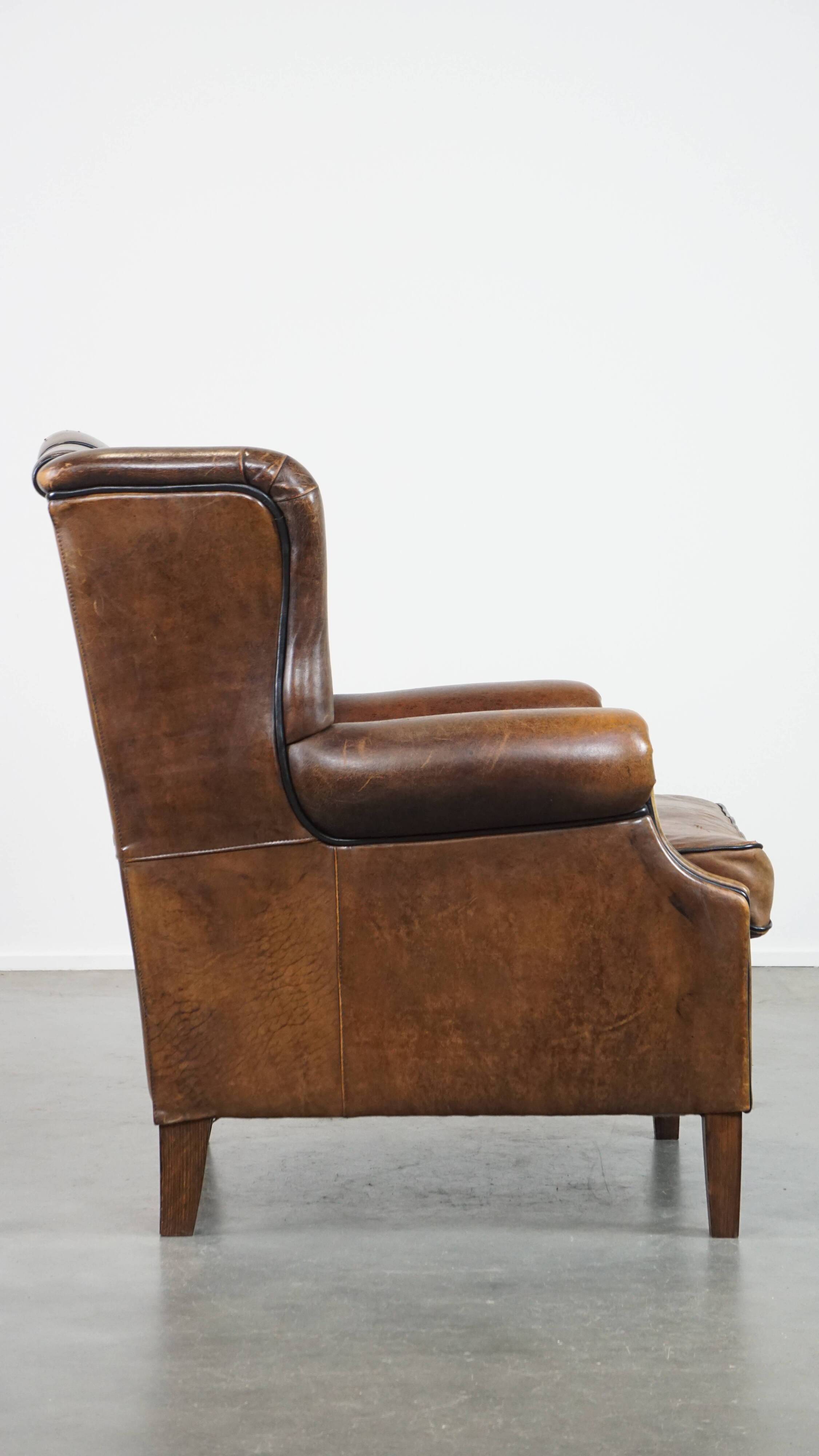 Vintage sheepskin wingback chair finished with black piping