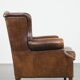 Vintage sheepskin wingback chair finished with black piping