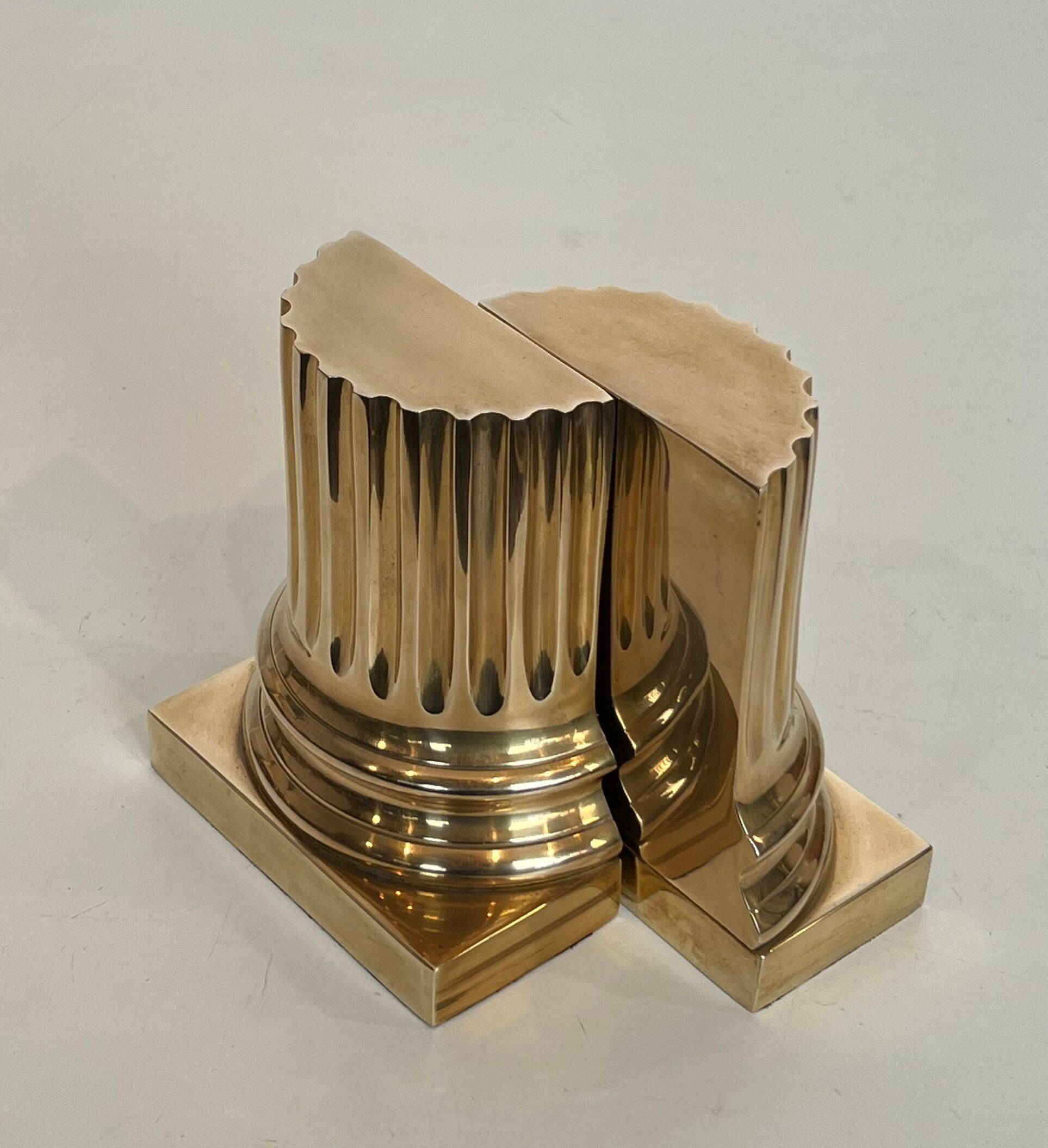A pair of brass bookends representing columns.