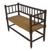 Vintage 'bobbin' bench with a rush seat, 1920s design with armrests.