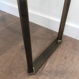 Console en acier brossé et laiton et plateau formé d'une dalle de verre. Travail français. Vers 1970