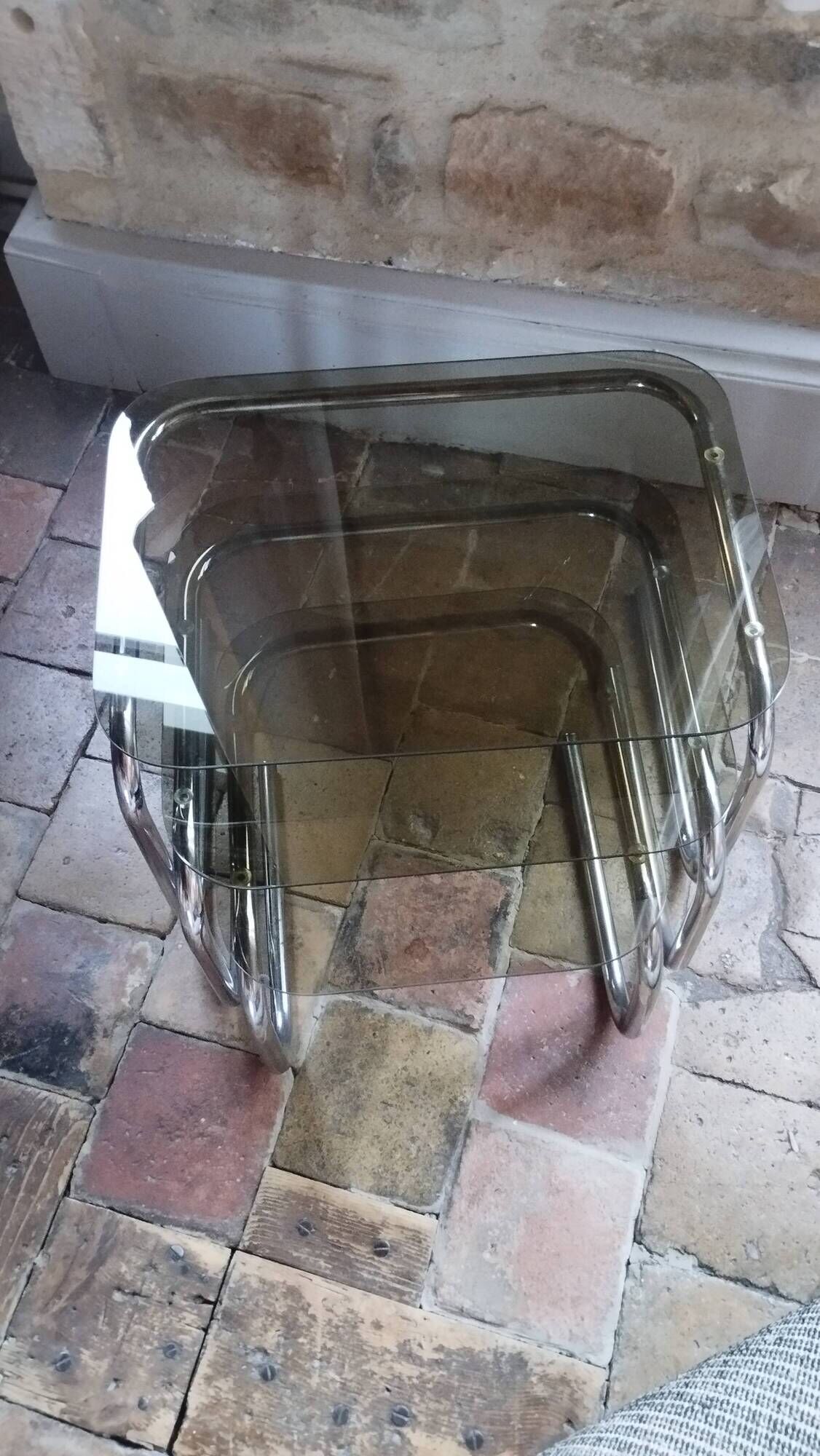 Nest of tables in glass and chrome steel.