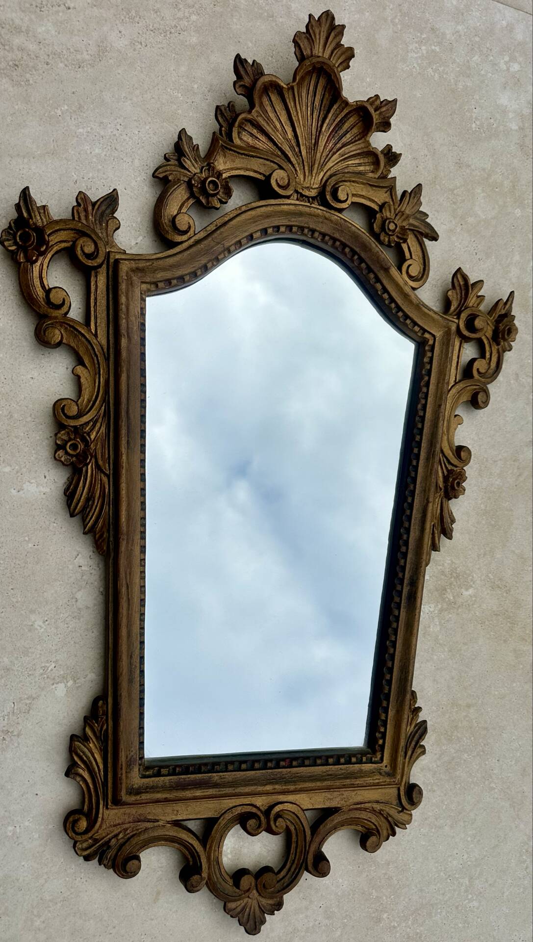 Carved and gilded wooden wall mirror.