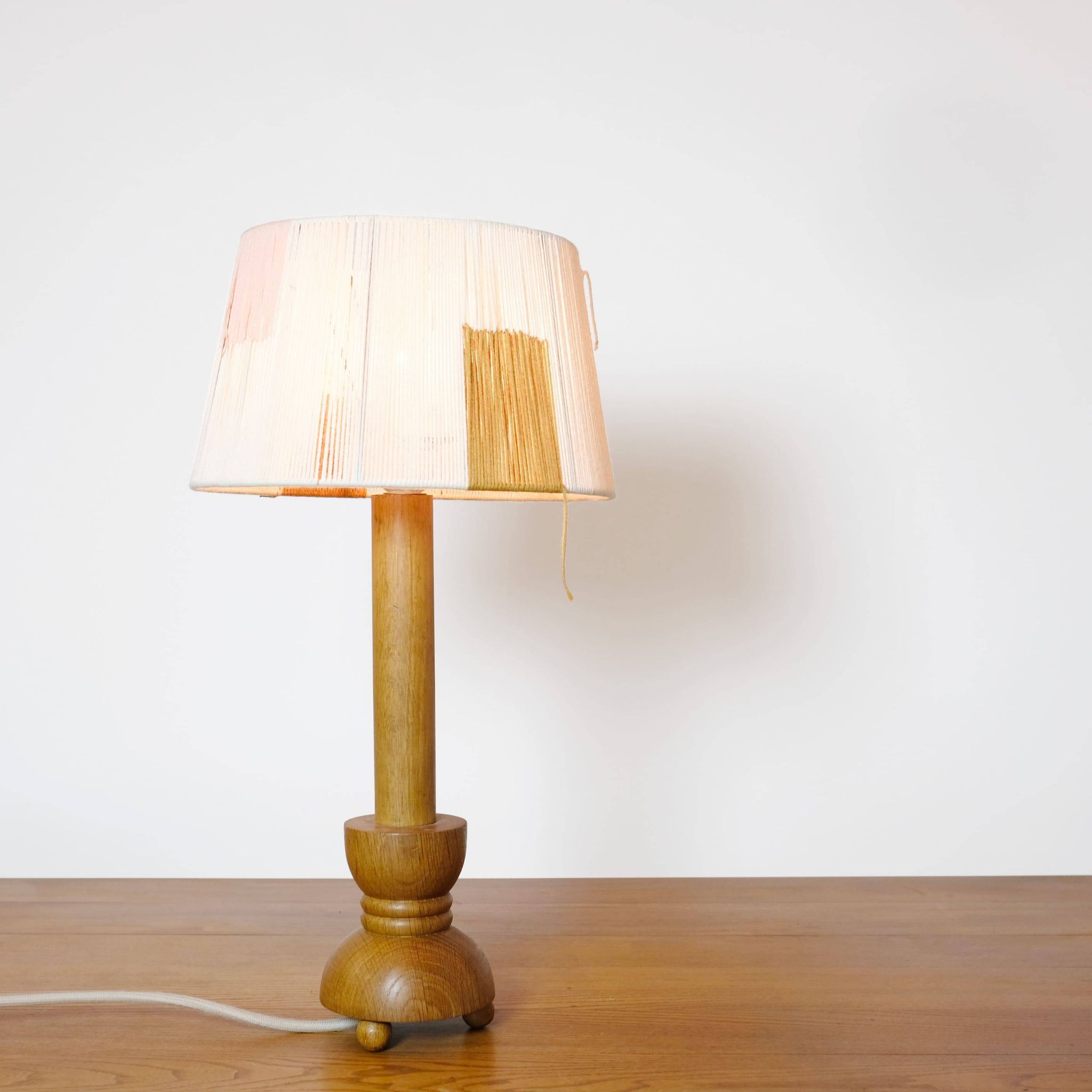 Wooden candle holder mounted as a lamp and its rope shade, 47.5cm.