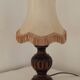 Mid-century French table lamp made of turned carved wood with a fringed shade.
