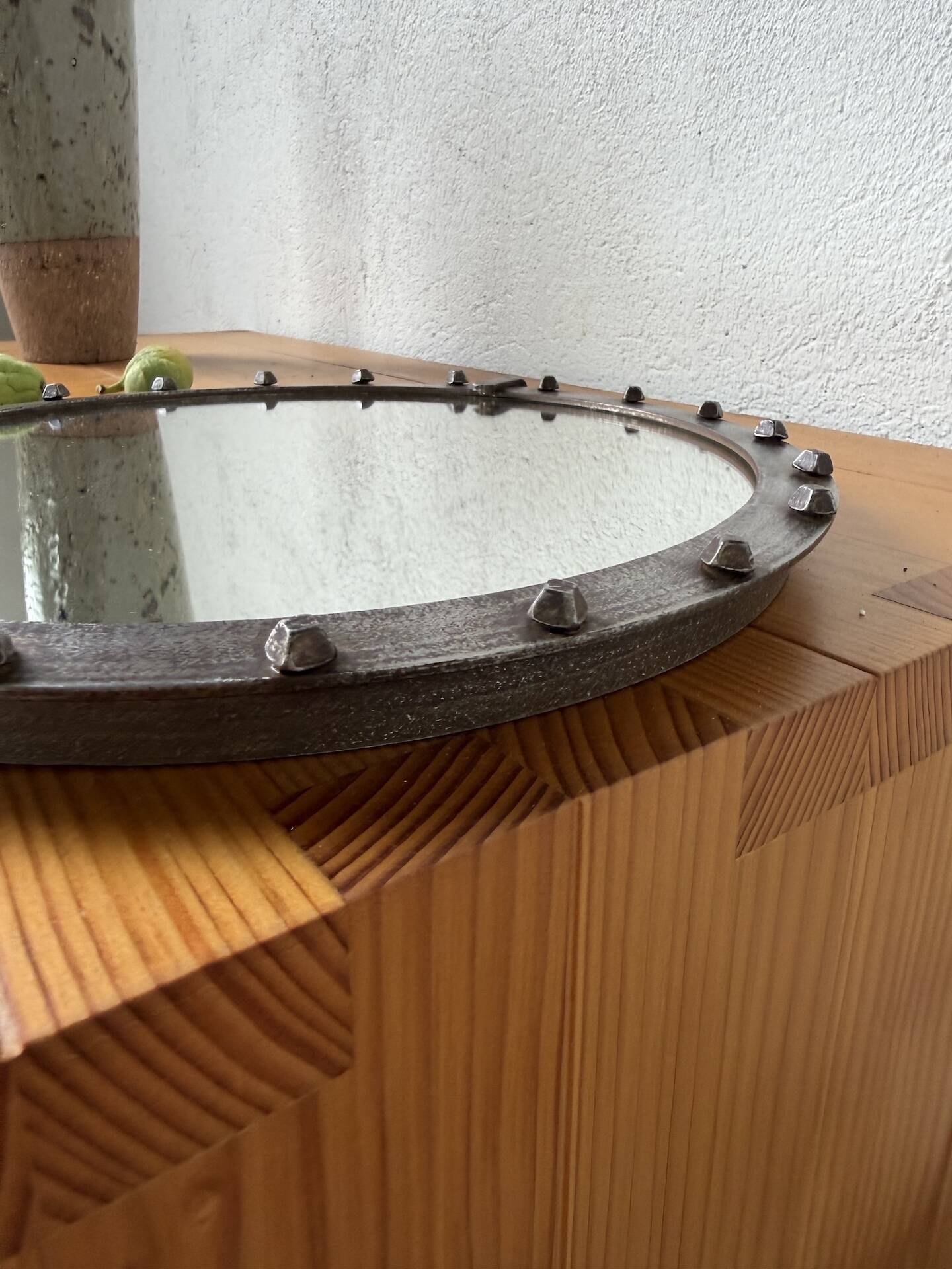 Brutalist round mirror with wrought iron and studs.