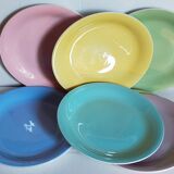 Seven pastel-colored plates mixed with vintage earthenware