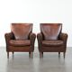 Ensemble de deux fauteuils en cuir de mouton vintage au caractère marqué.