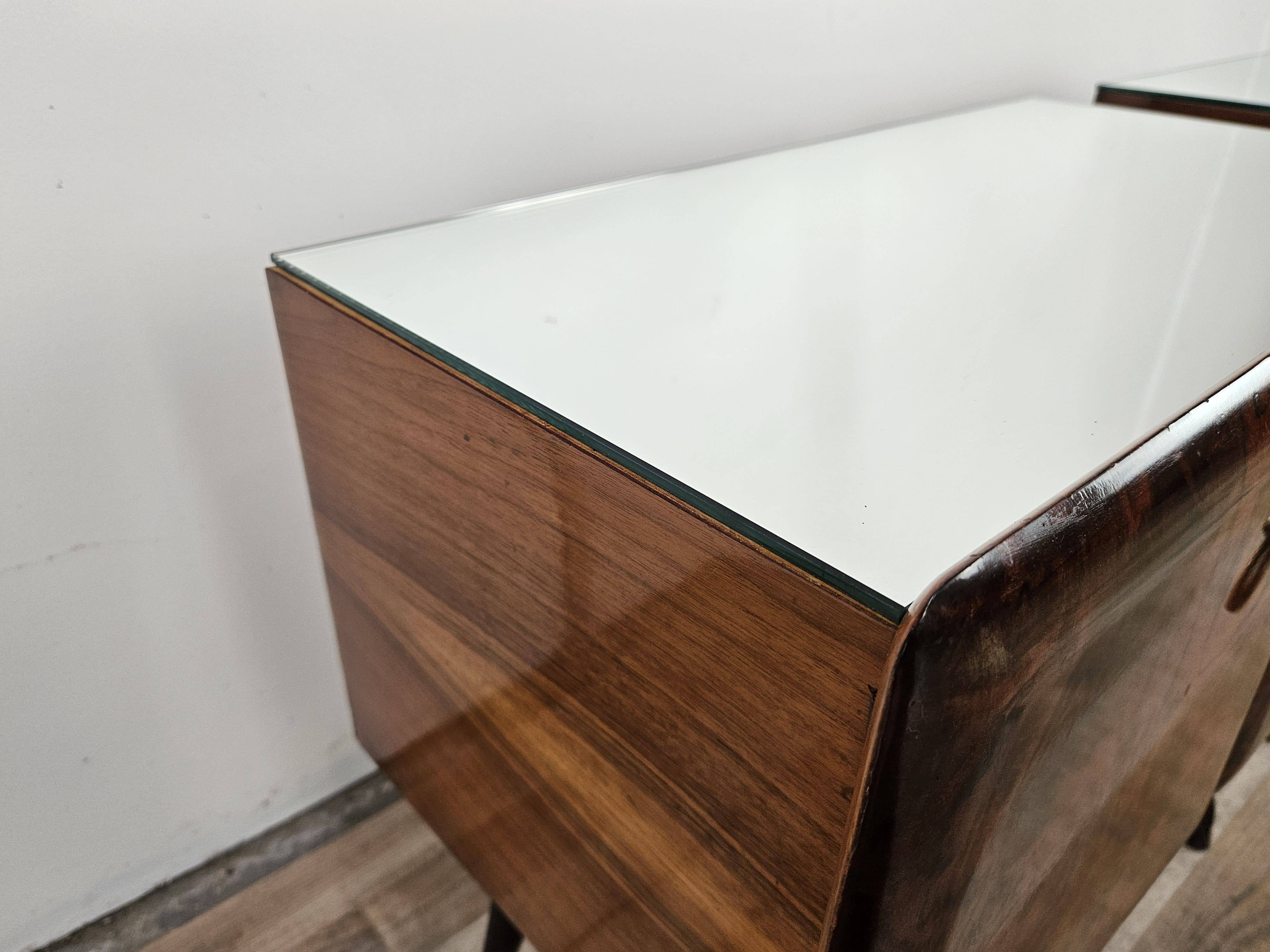 Mid-century mahogany bedside tables with mirrored tops.