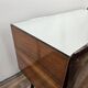 Mid-century mahogany bedside tables with mirrored tops.