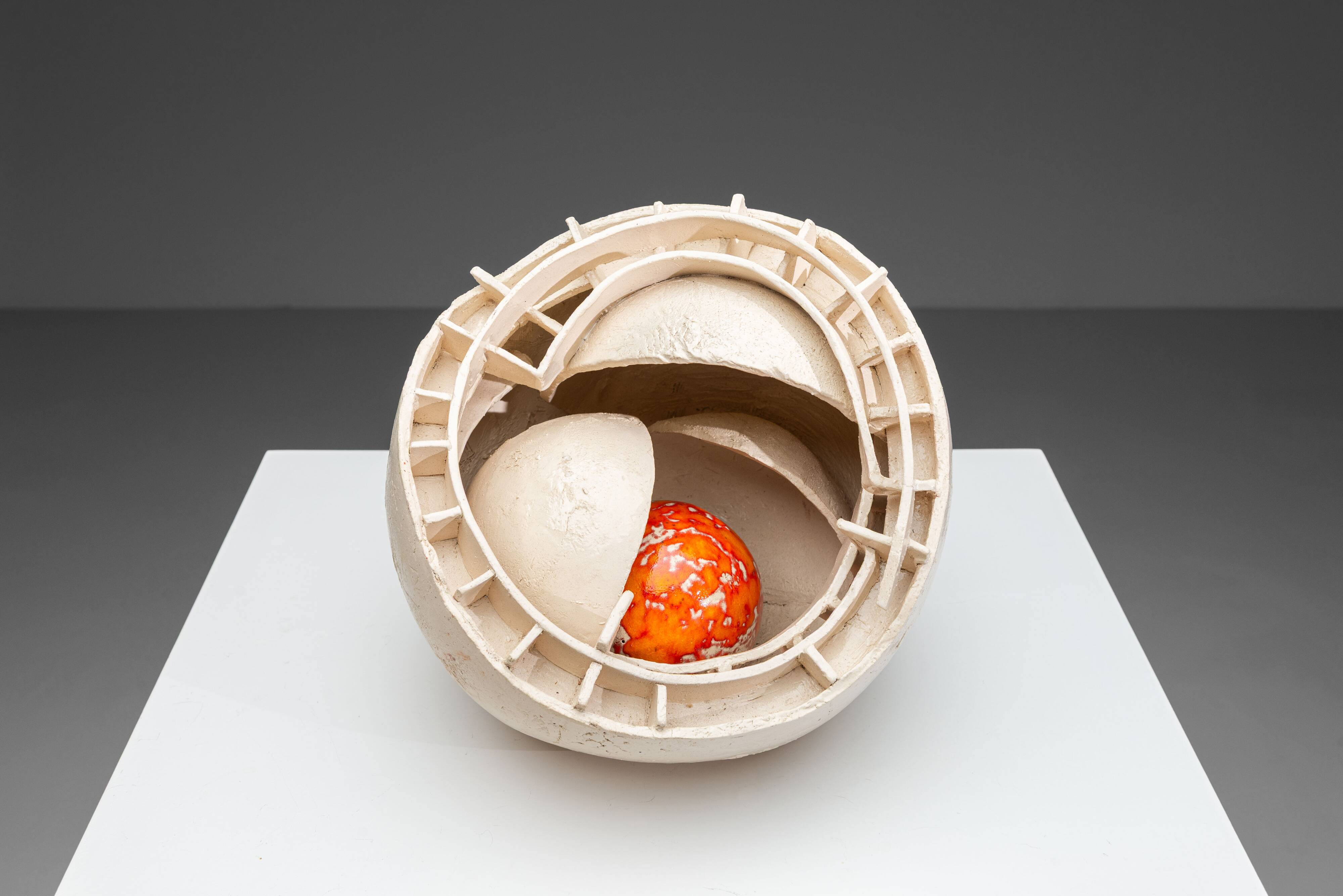 Sculpture en céramique abstraite avec un noyau orange.