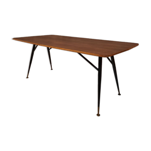 Table à manger en bois de teck et pieds en métal peint.