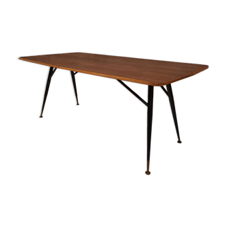 Table à manger en bois de teck et pieds en métal peint.