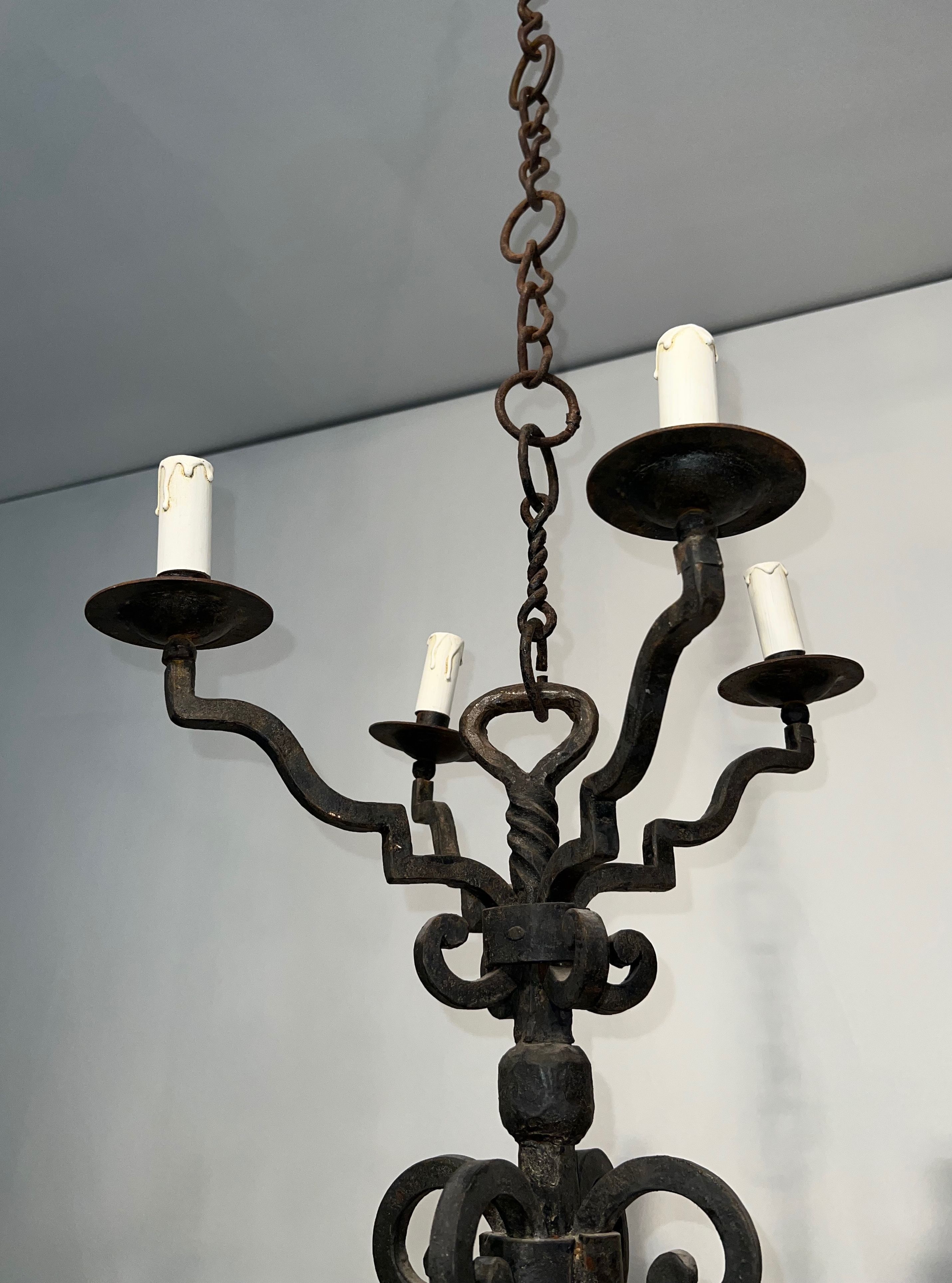 Two-tiered wrought iron chandelier with eight light arms in Gothic style.