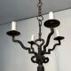 Two-tiered wrought iron chandelier with eight light arms in Gothic style.
