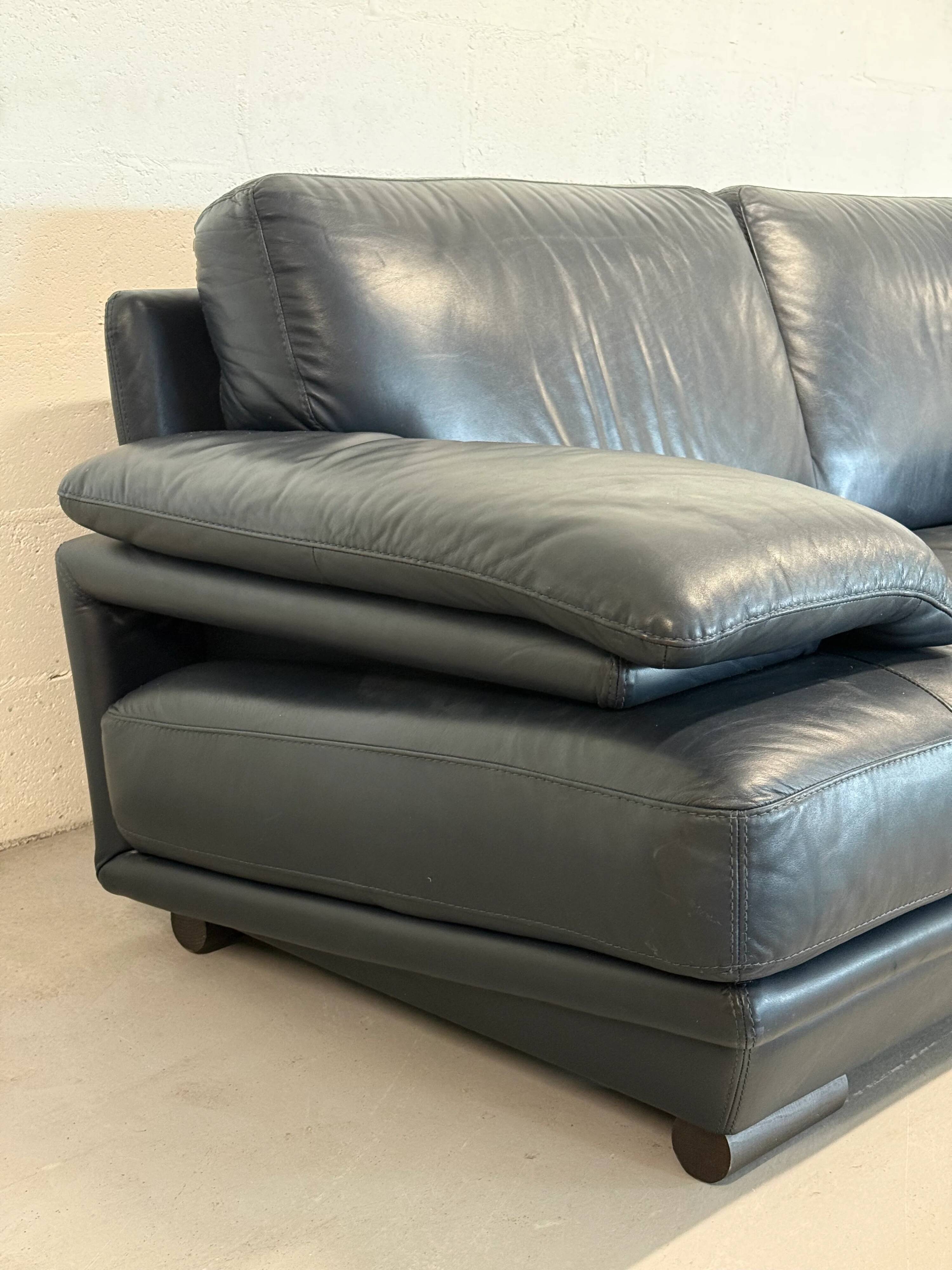 Two-seater Natuzzi sofa in navy blue leather.