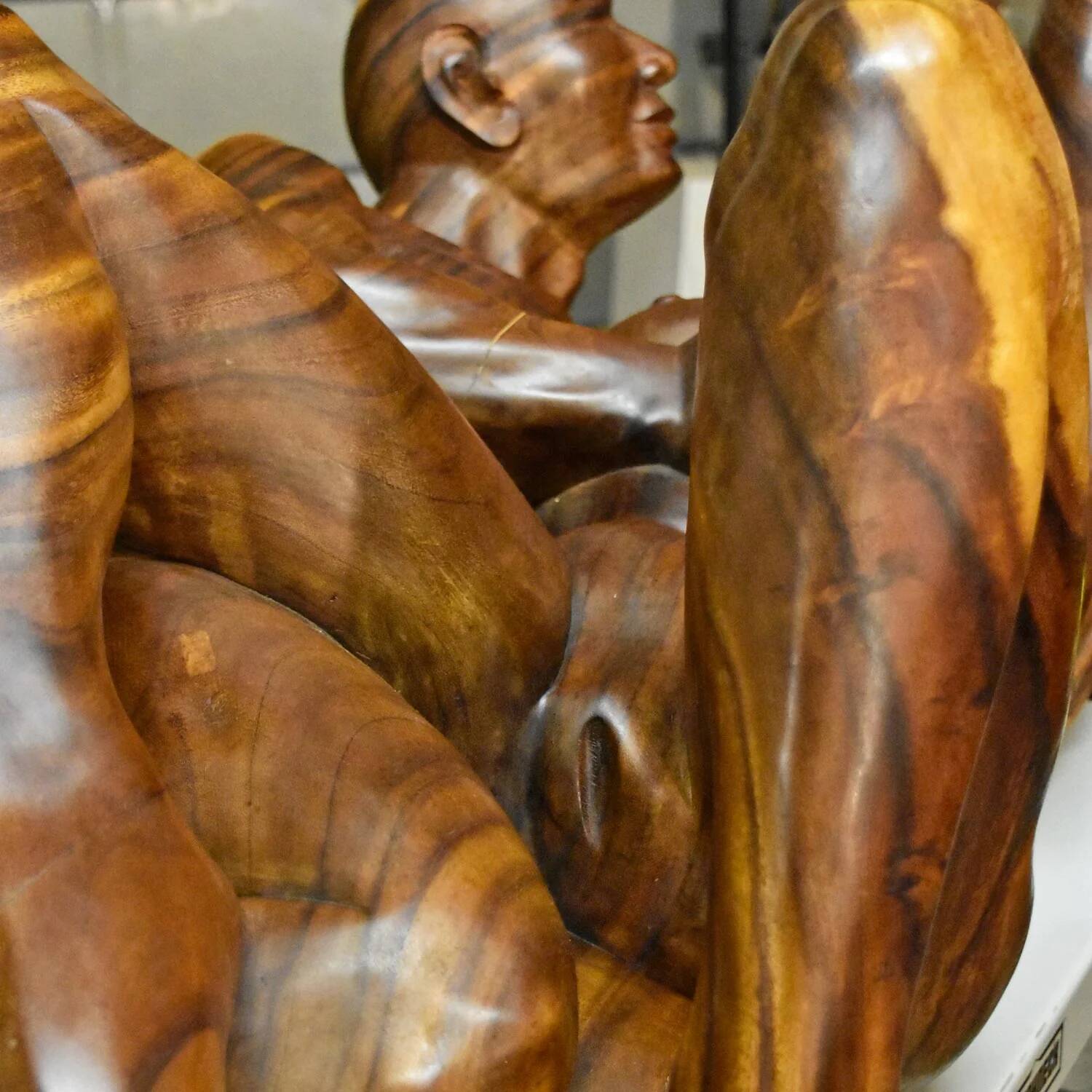 Table basse en bois exotique de monkey pod sculptée à la main représentant un couple enlacé.