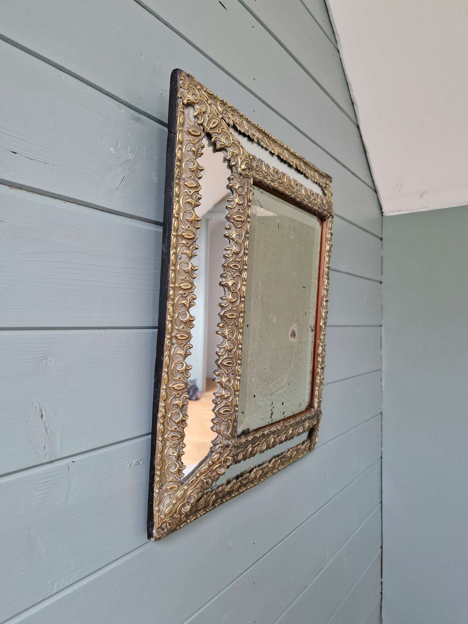 Mirror with repoussé brass frame, mercury glass, 19th century.