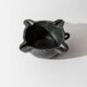 Vintage ceramic ashtray from the 1960s, black, hand-sculpted texture, organic shape.