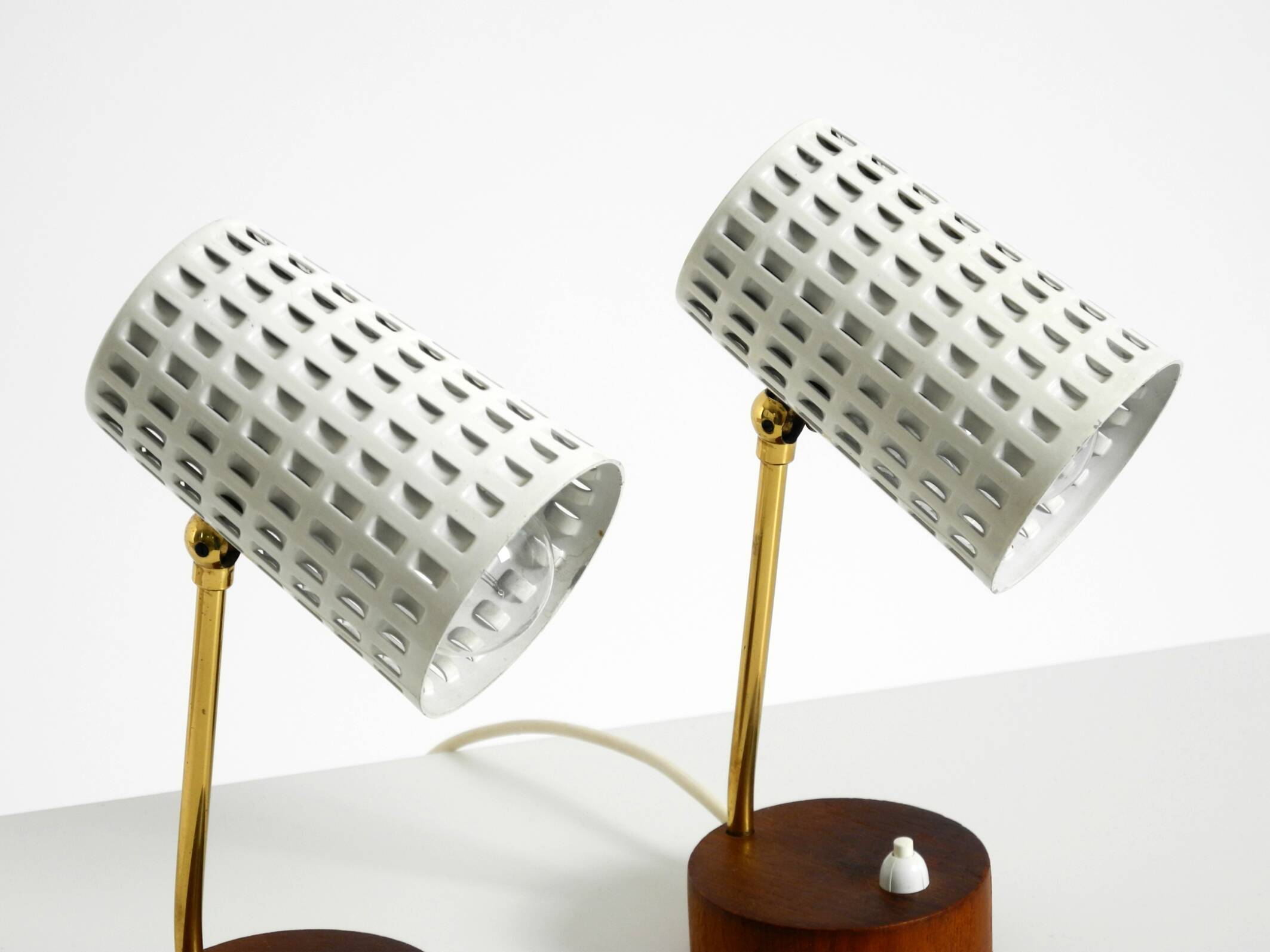 A pair of mid-century modern bedside lamps with perforated metal shades