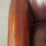 Comfortable, rugged cognac-colored sheepskin club armchair with a characteristic seat cushion