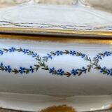 Old soup bowl with a golden border and decorated with small blue flowers