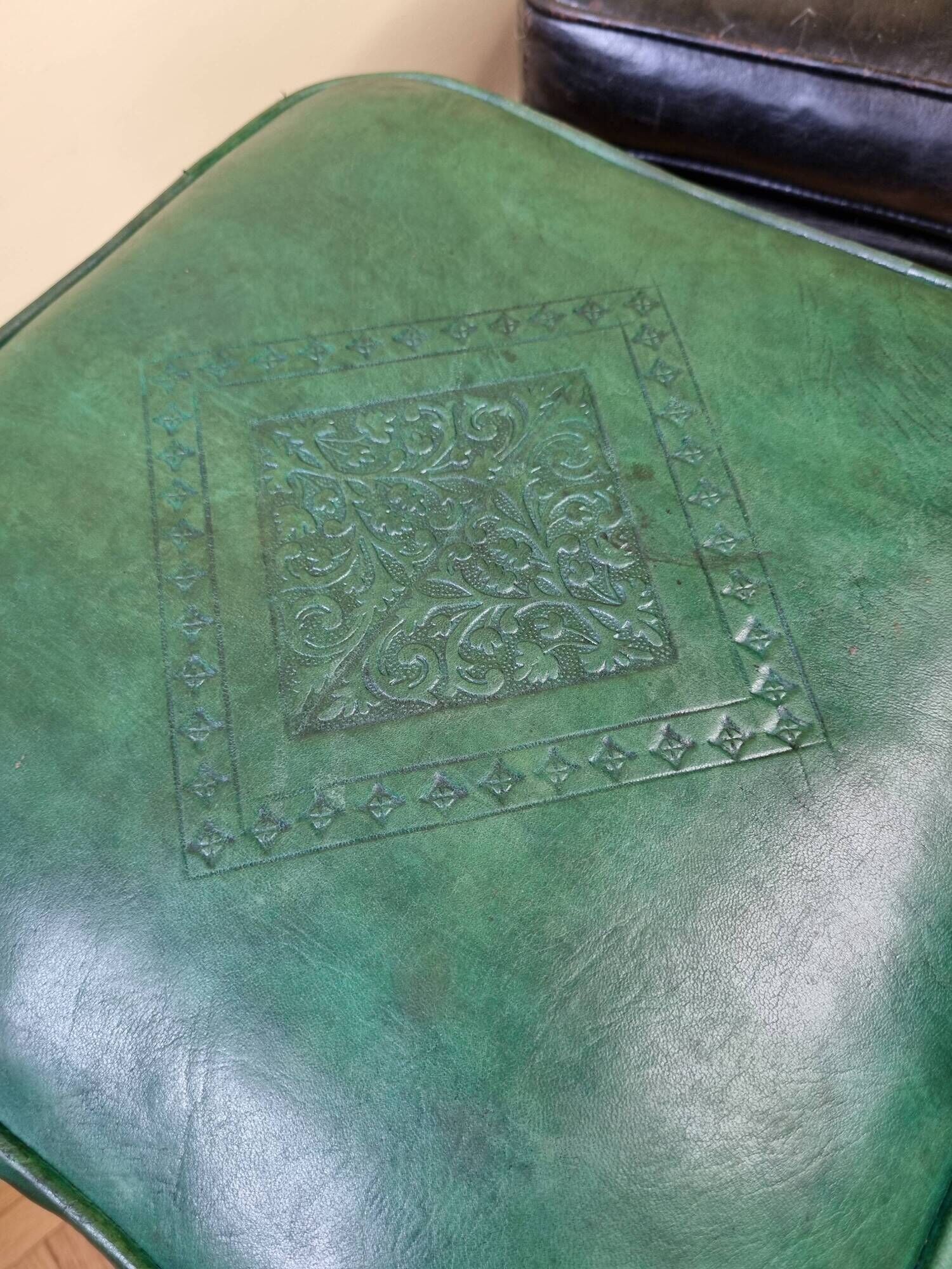 Pair of Moroccan poufs in stamped leather with a carved wooden base, Rabat