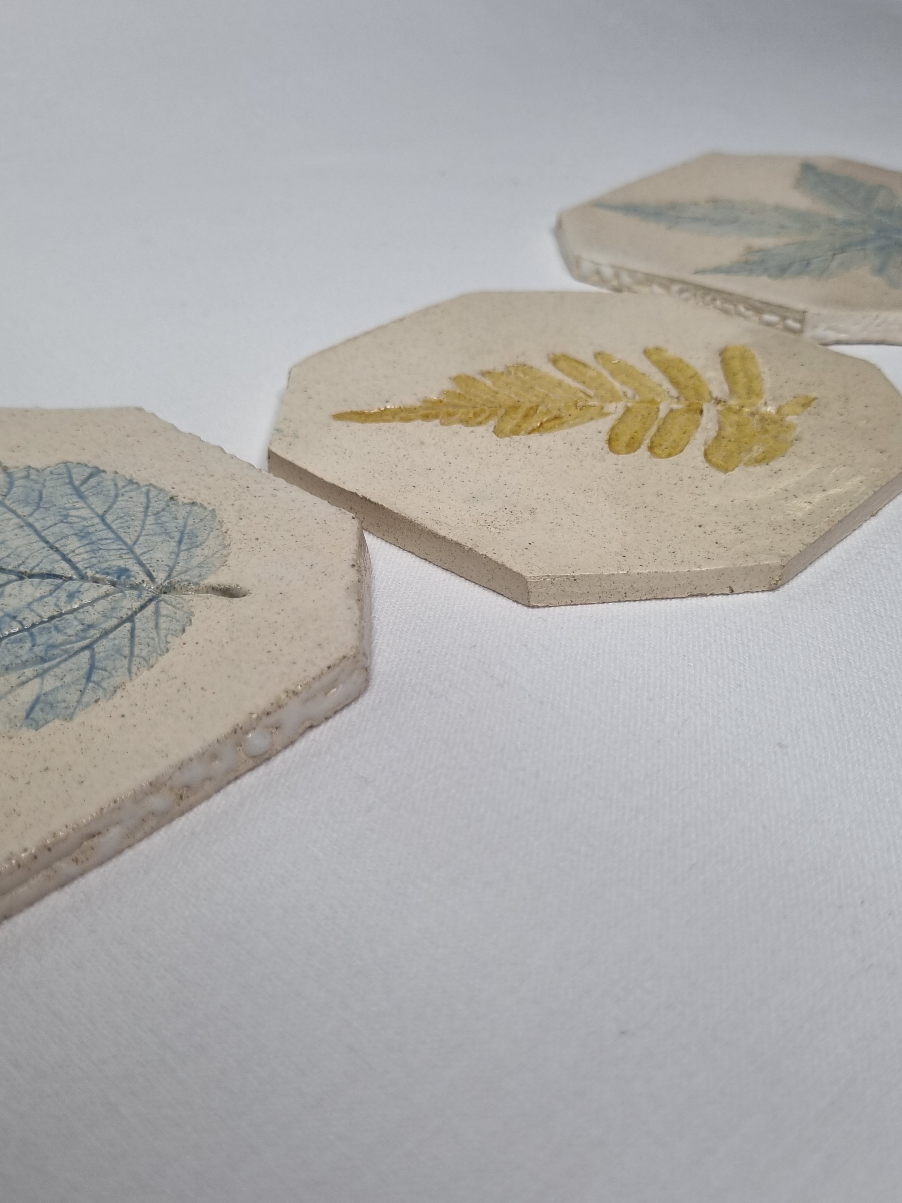 Three enamelled ceramic under glass, footprints of plants from Canada