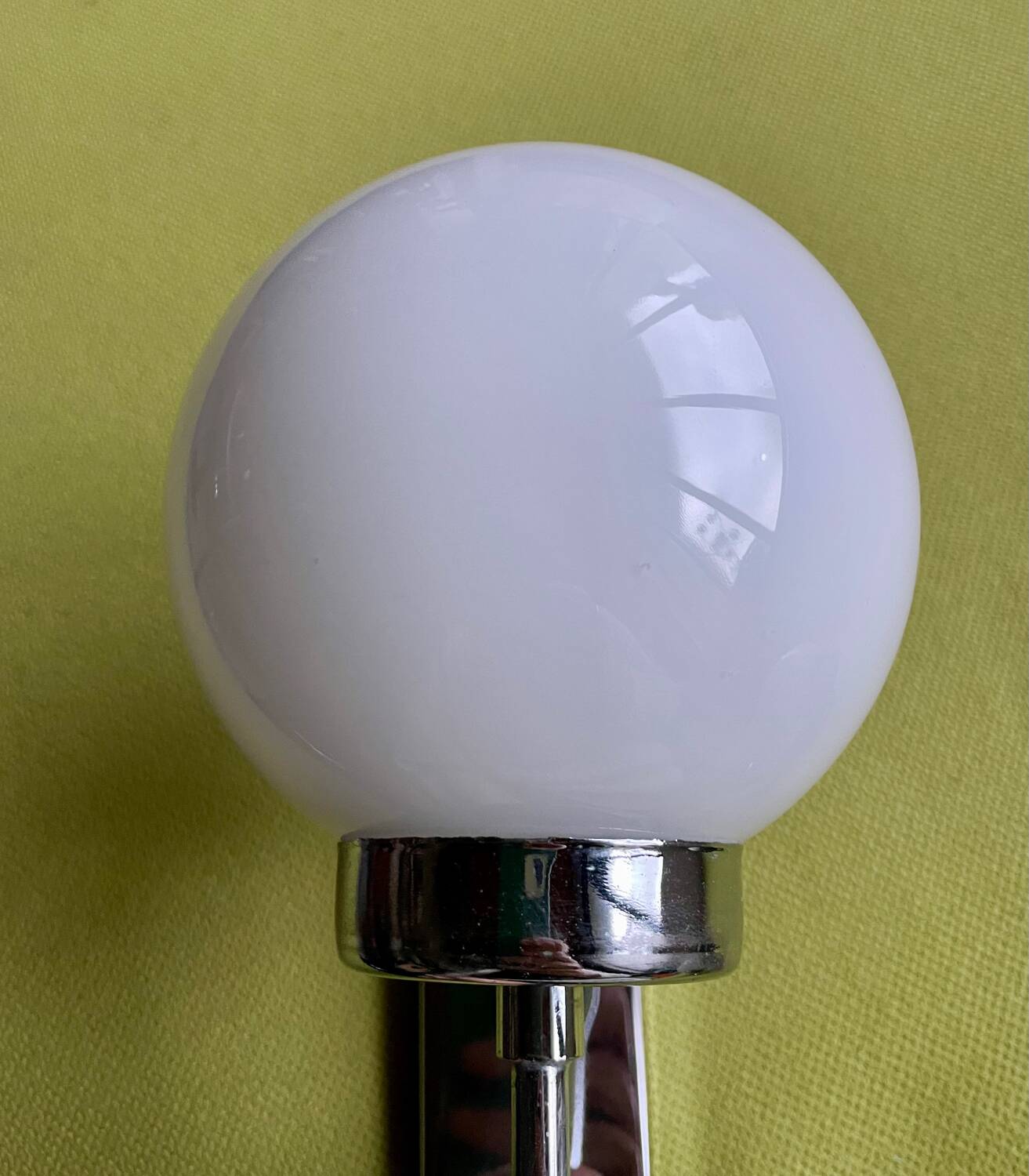 Pair of chrome metal wall lights with white glass globe.