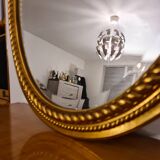 Beveled oval mirror in gilded wood 78×58cm