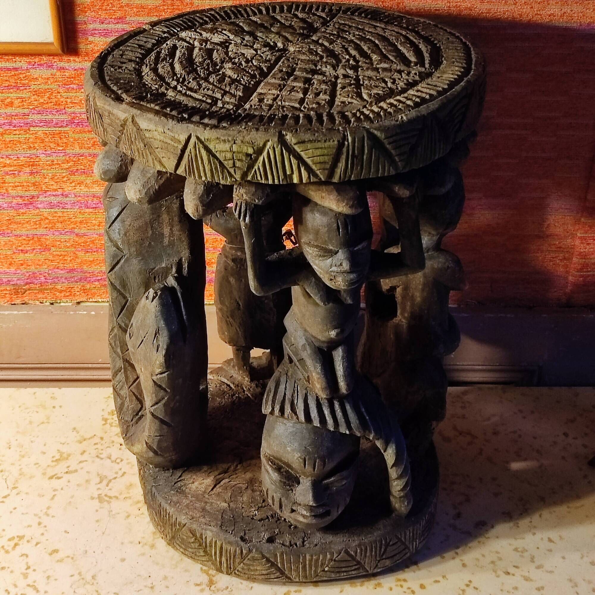 African wooden stool carved in the shapes of characters