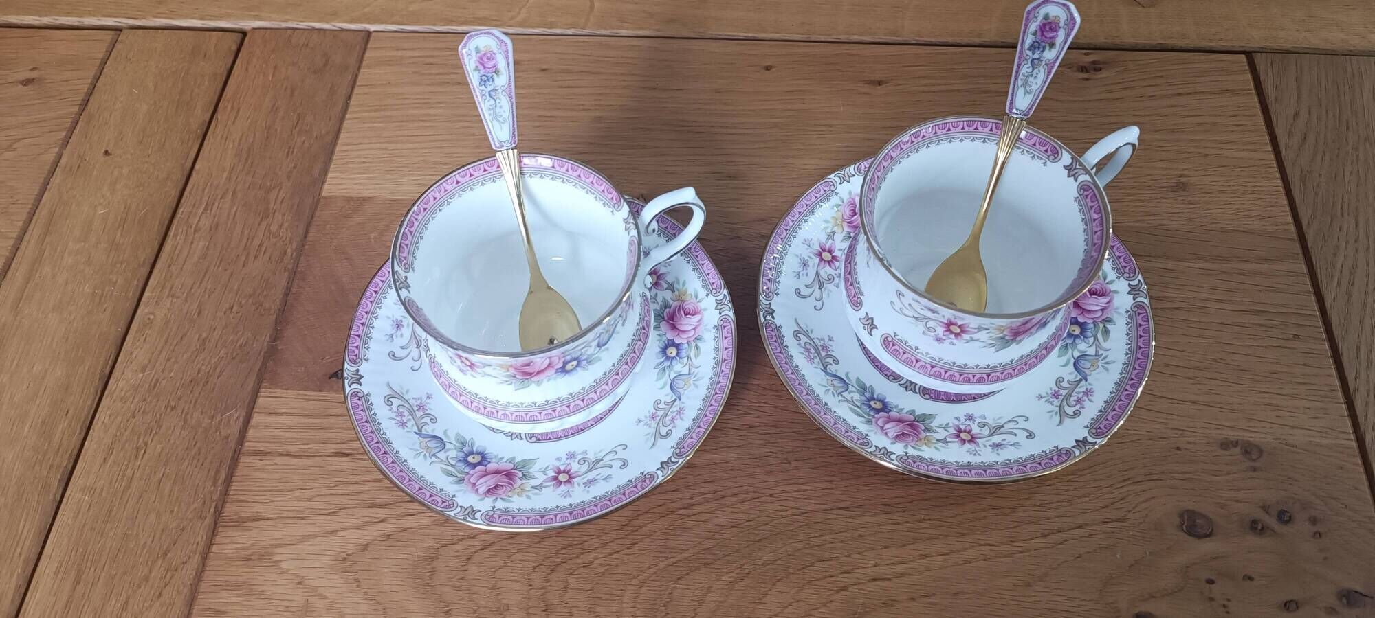 Duo of English porcelain tea cups from Queen's Richmond and spoons.