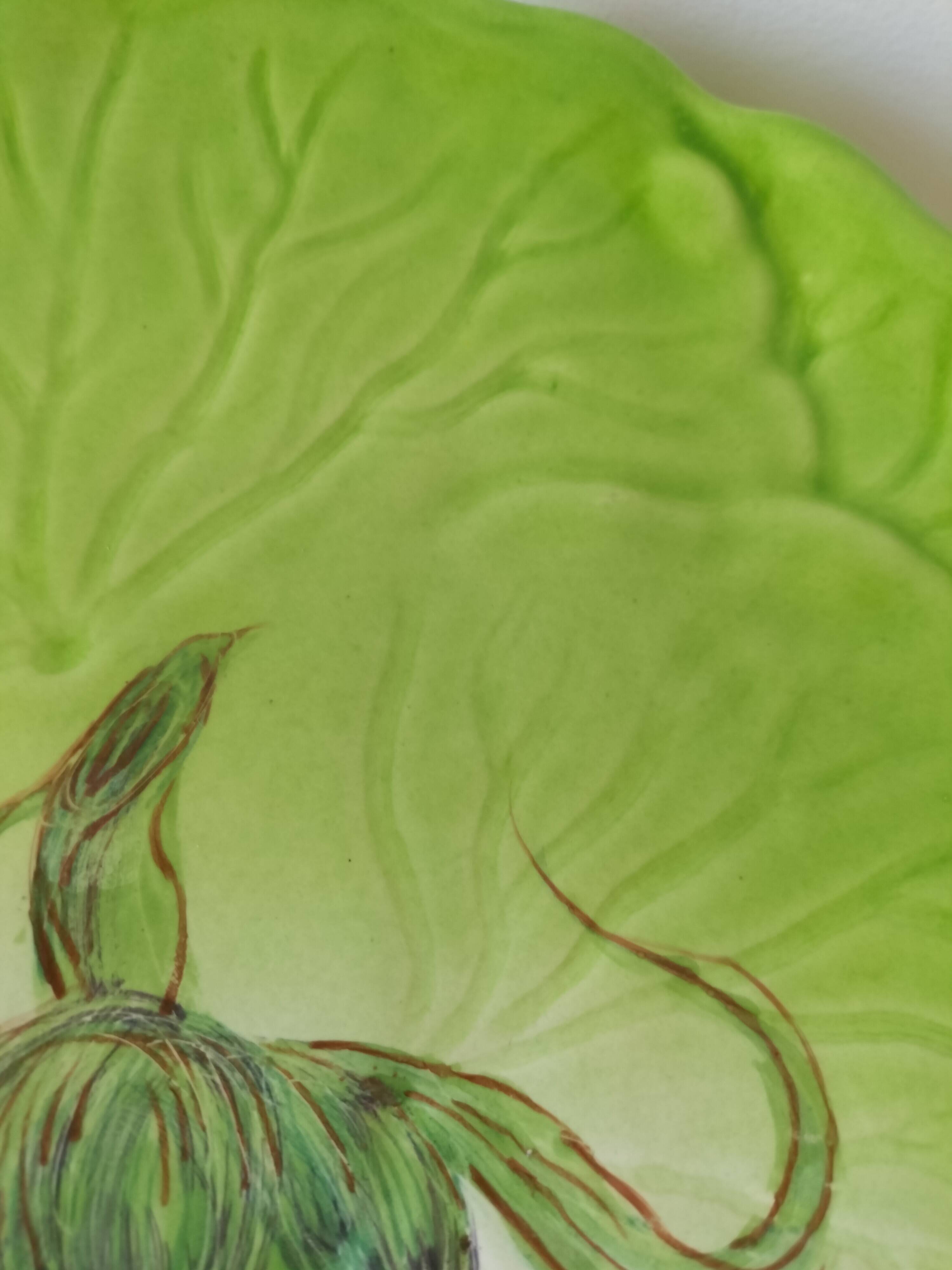 4 hand-decorated earthenware plates with vegetable and green leaf designs.