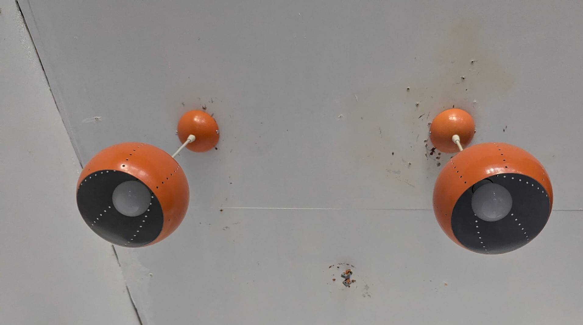 Paire de globes 70's en métal laqué orange.