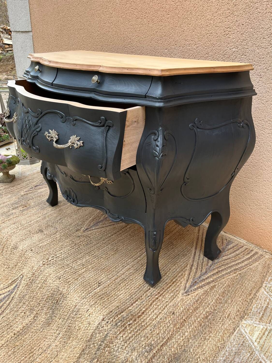 Curved commode painted in black and wood.