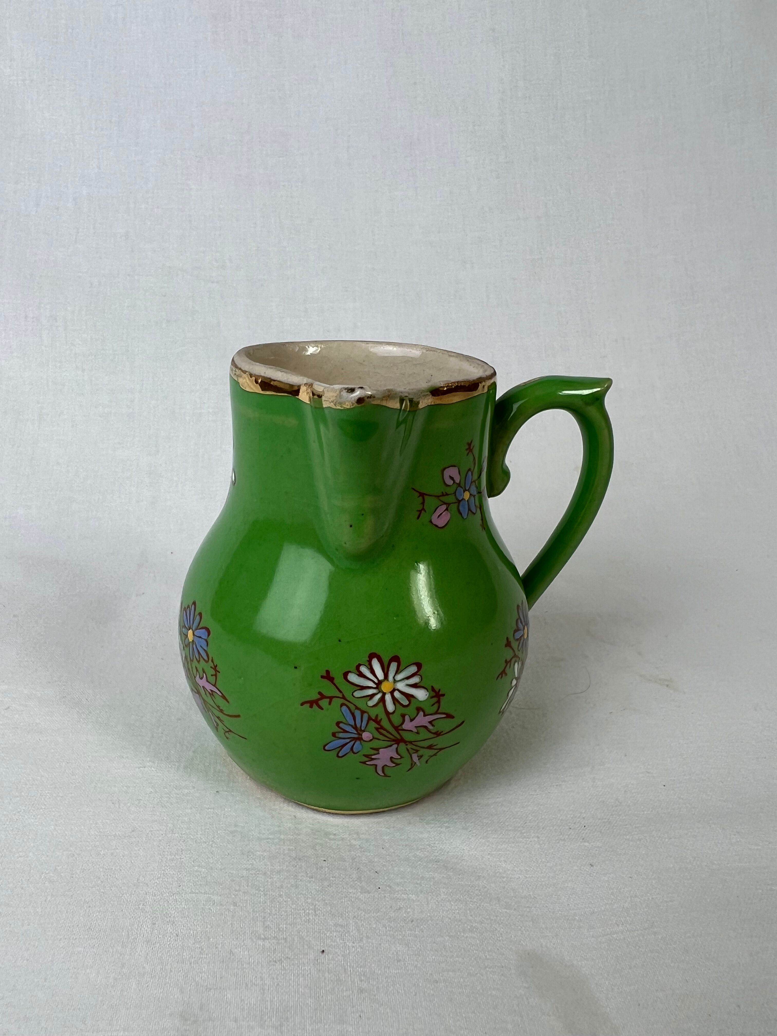 Green milk jug with enamelled flowers