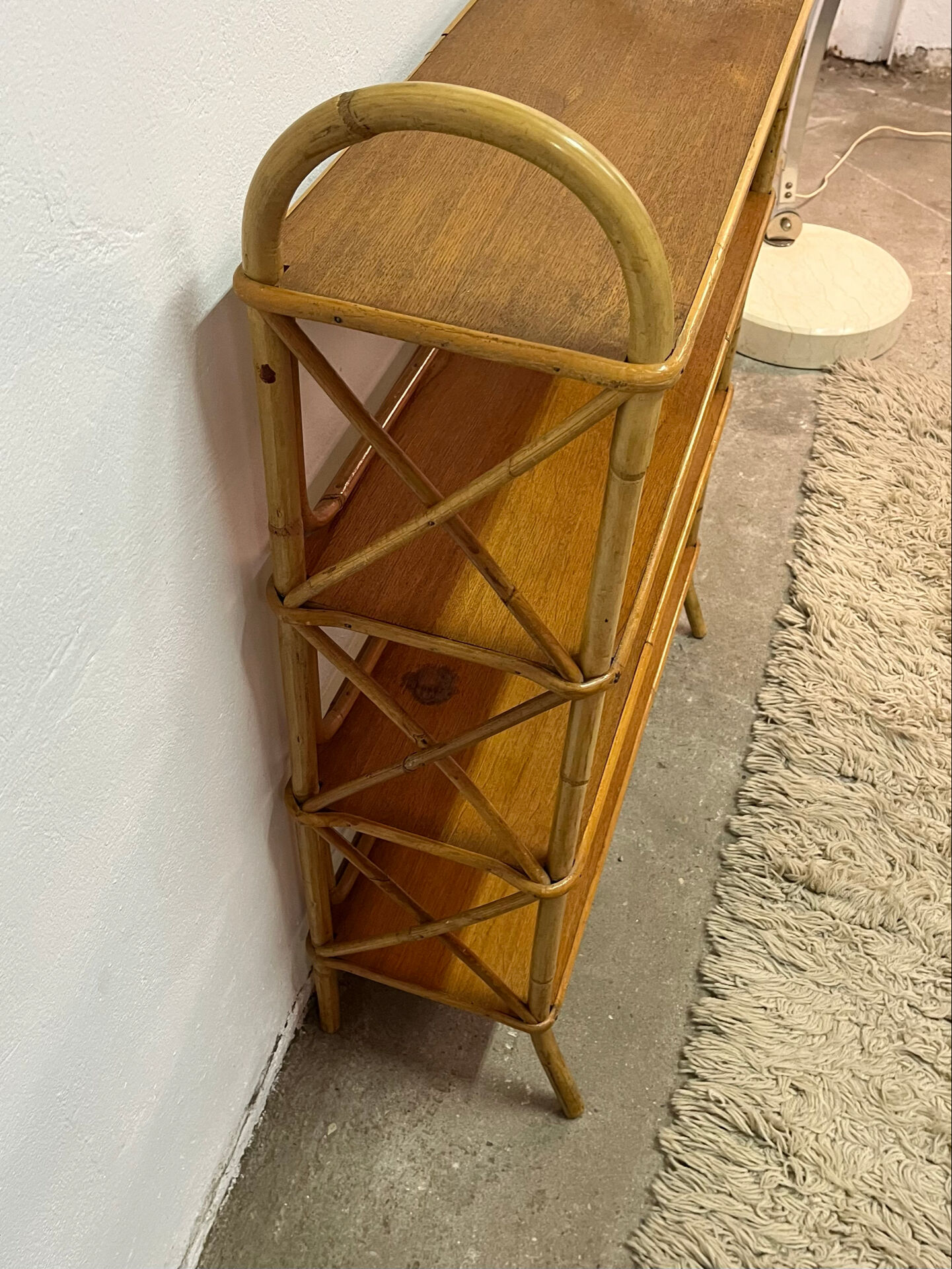 Vintage shelf on legs made of rattan and wood.