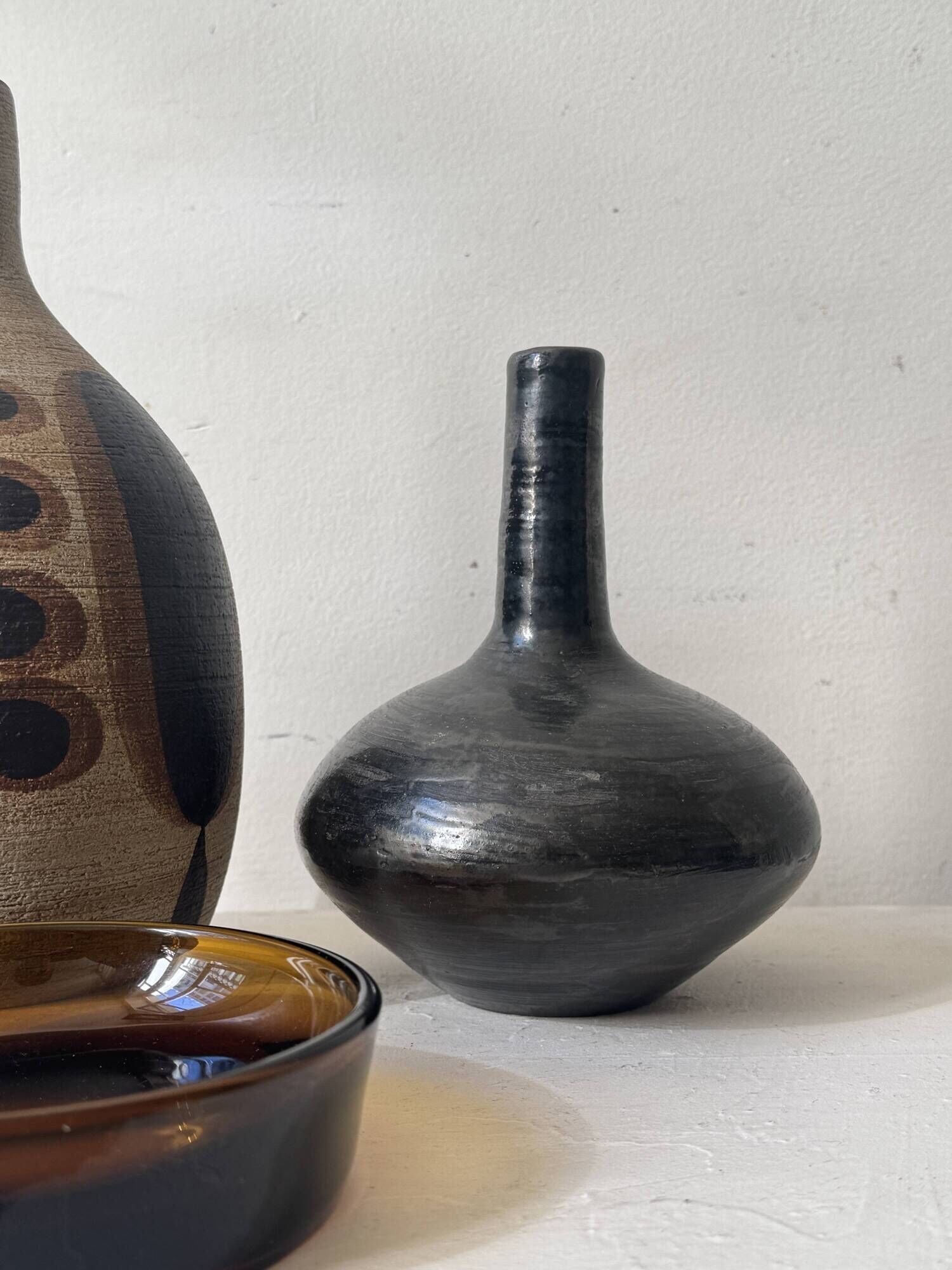 Glazed black ceramic vase with a single stem, signed, circa 1950.