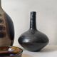 Glazed black ceramic vase with a single stem, signed, circa 1950.