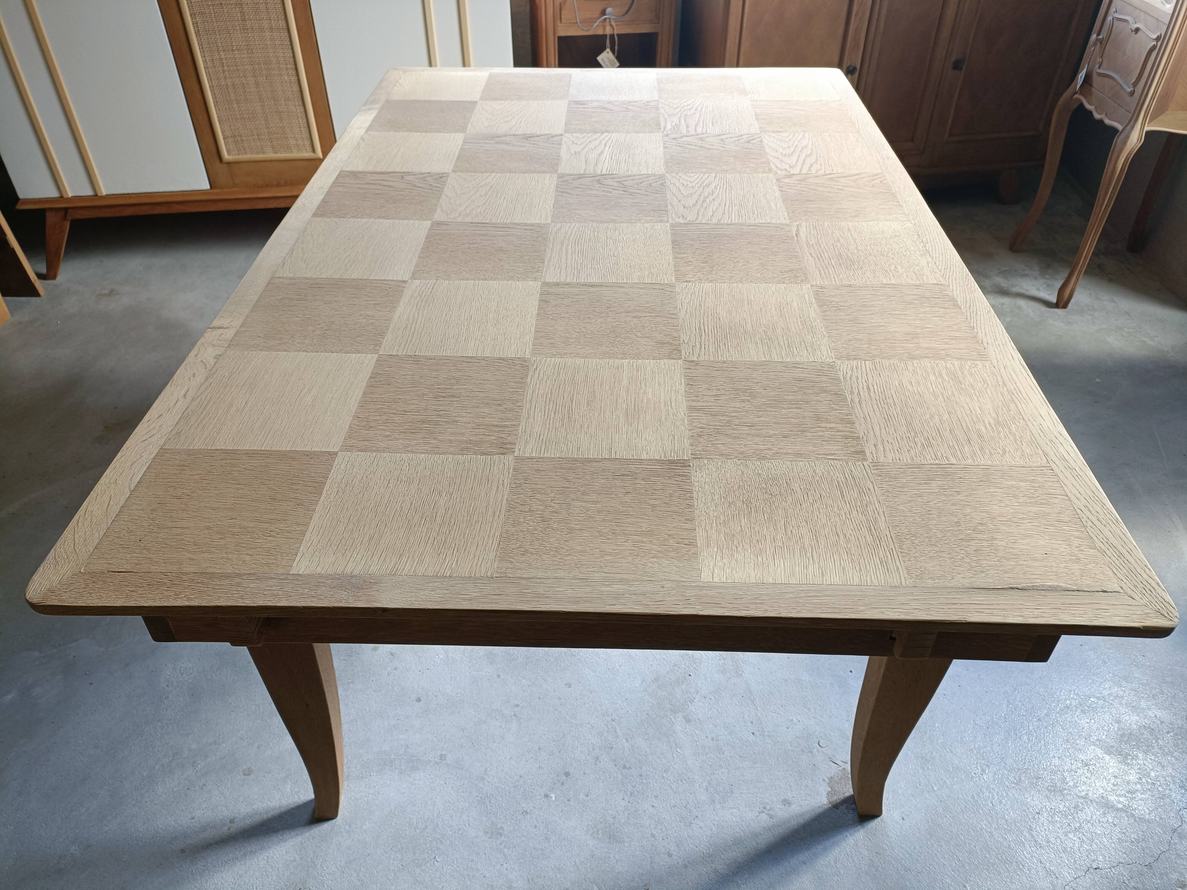 Oak dining table with a checkerboard top and extensions.