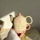 Vintage porcelain teapot and cup set with pink and beige floral and gingham pattern