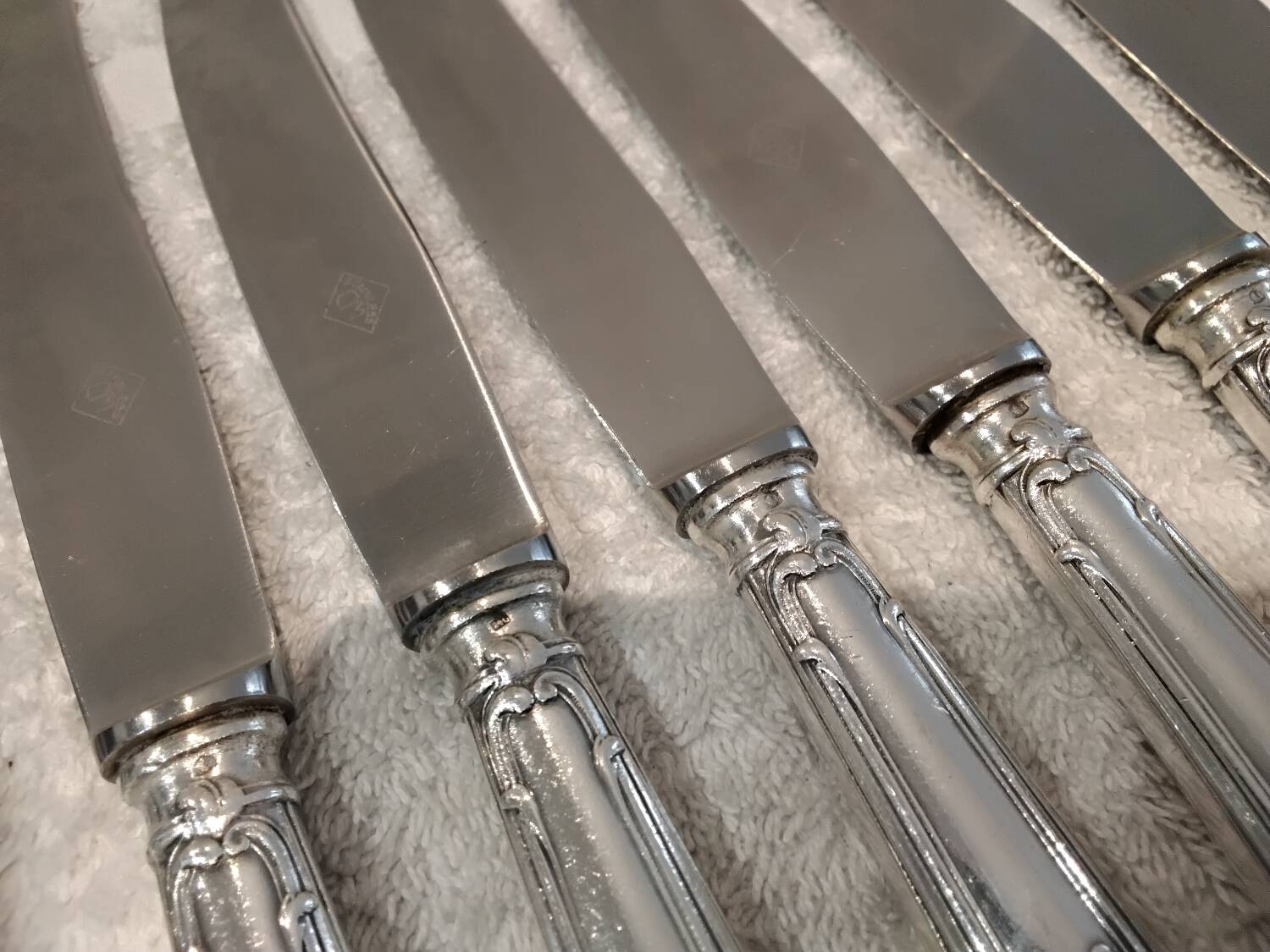 12 silver-plated metal table knives with rocaille ribbon decoration, 25.1 cm