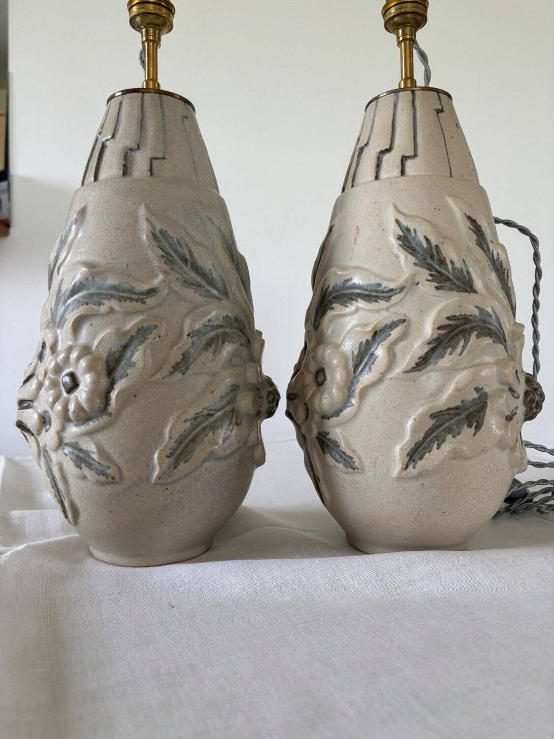Pair of white glazed stoneware lamp bases, 20th-century floral decoration.