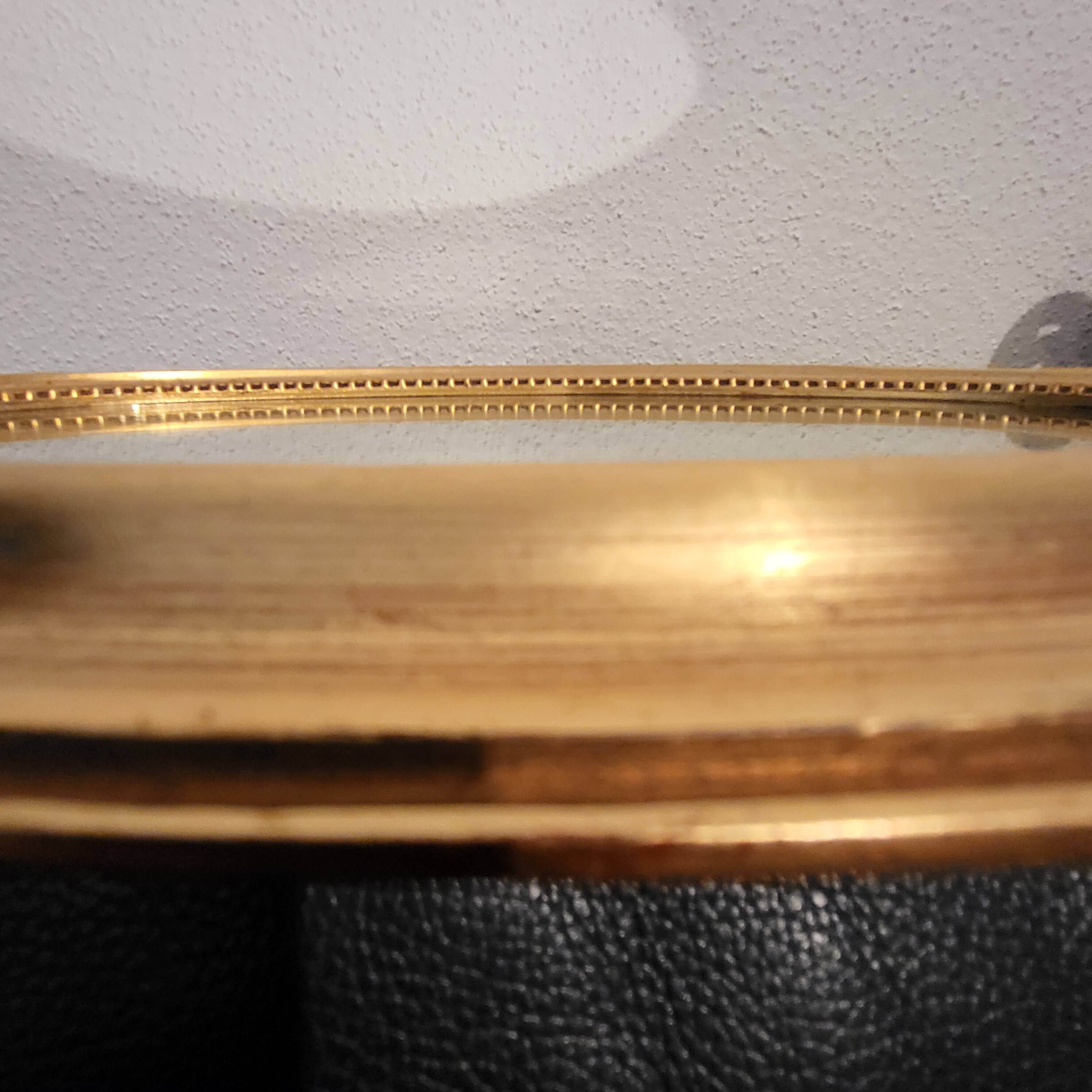 Oval mirror with golden wooden knot