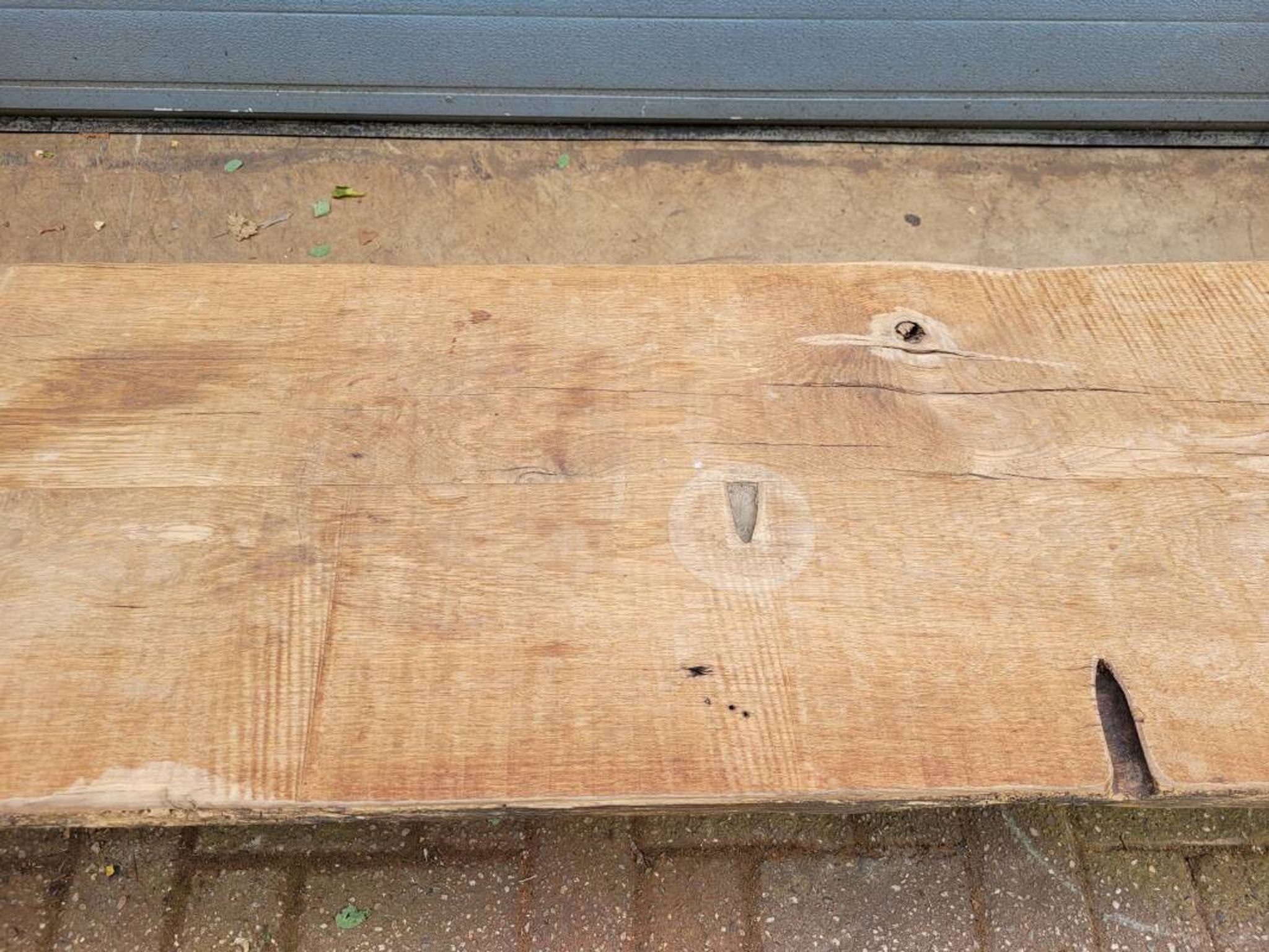 French country-style cast iron garden bench with old barn wood plank.