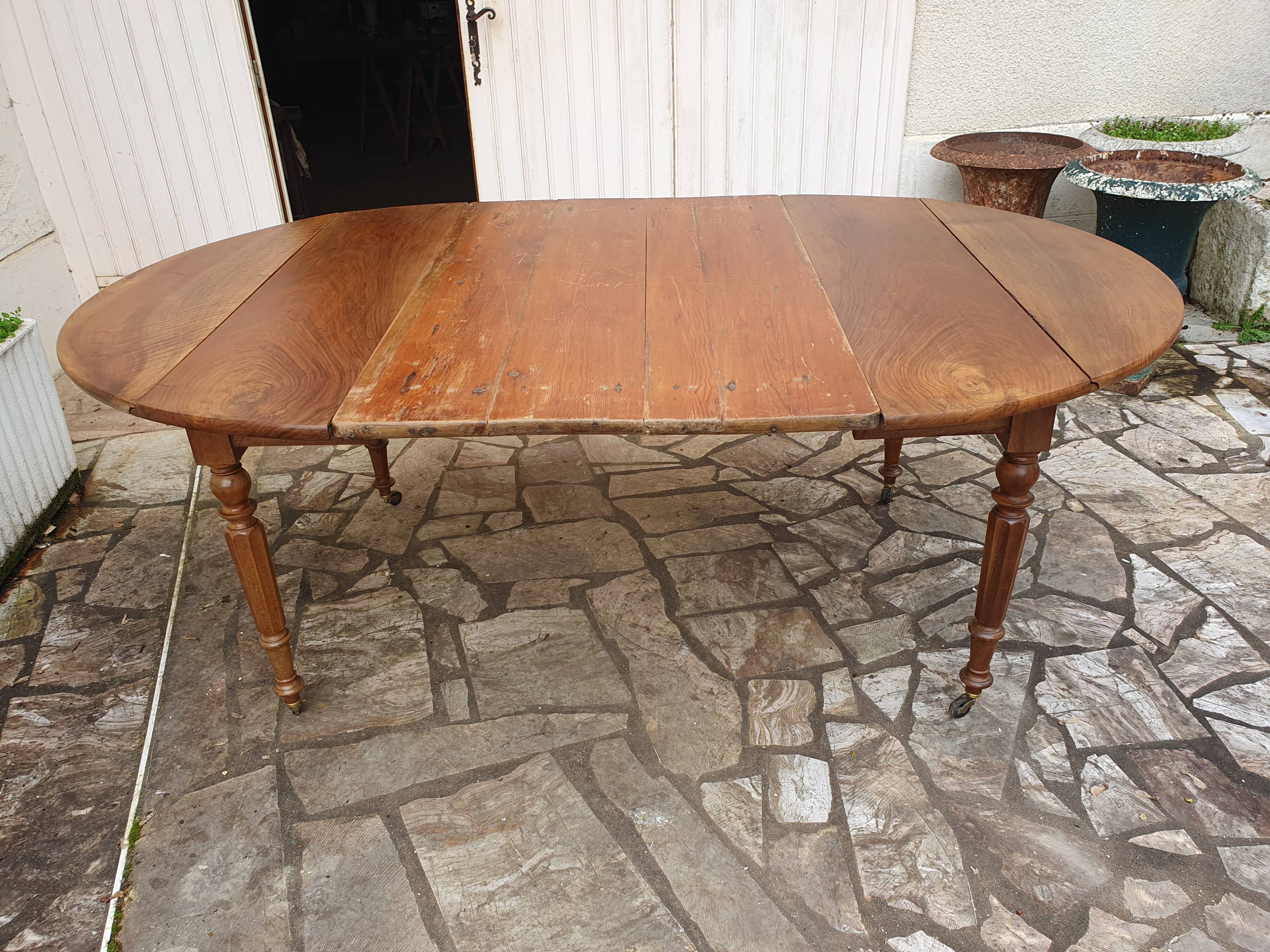 Round extending table in solid walnut, 19th century