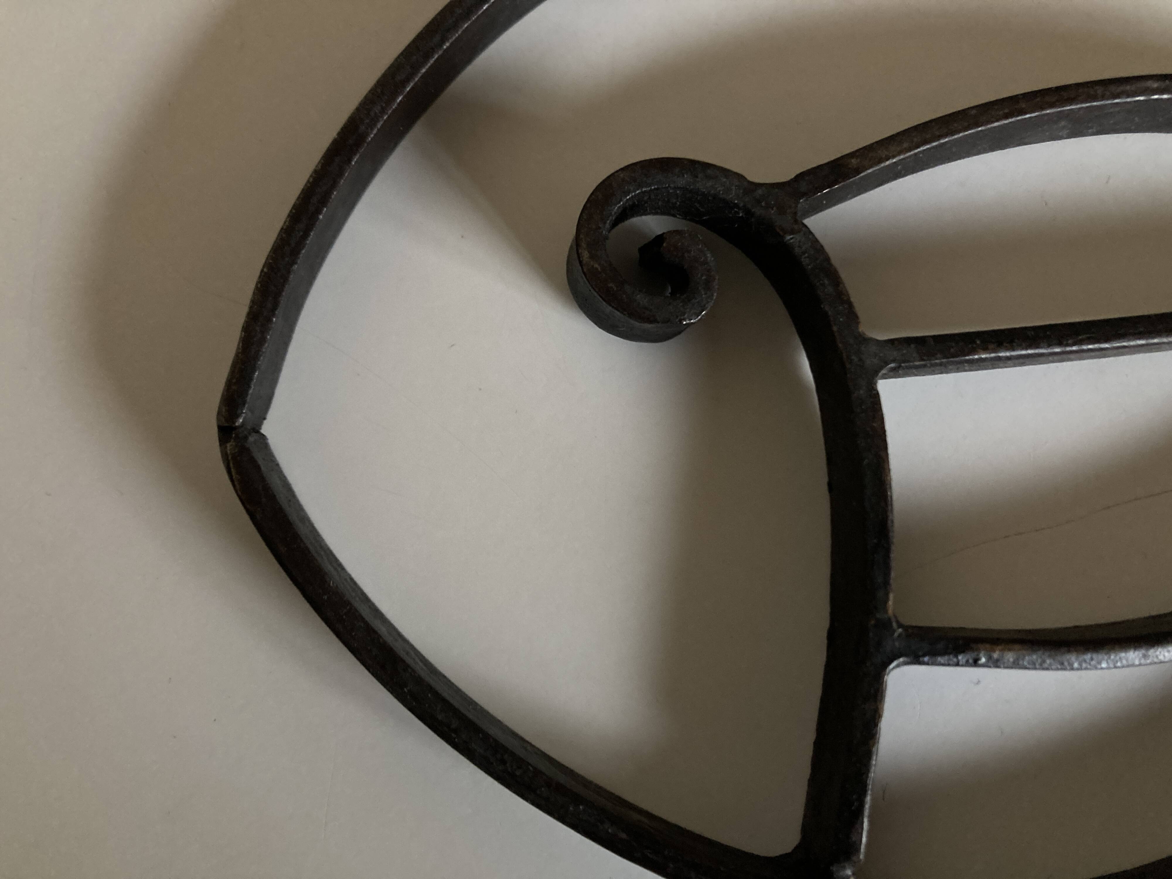 Modernist fish trivet in beaten iron, 1960.